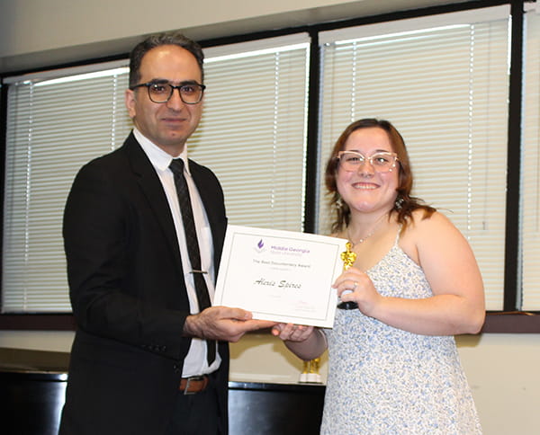 Alexis Spires (right) receives the Best Documentary Award from Zardosht Afshari, Assistant Professor of Film.
